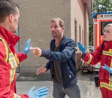 Eine zivile Person bedroht einen Feuerwehrmann. Eine zivile Person bedroht einen Feuerwehrmann.
