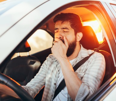 Ein Mann gähnt im Auto. Ein Mann gähnt im Auto.